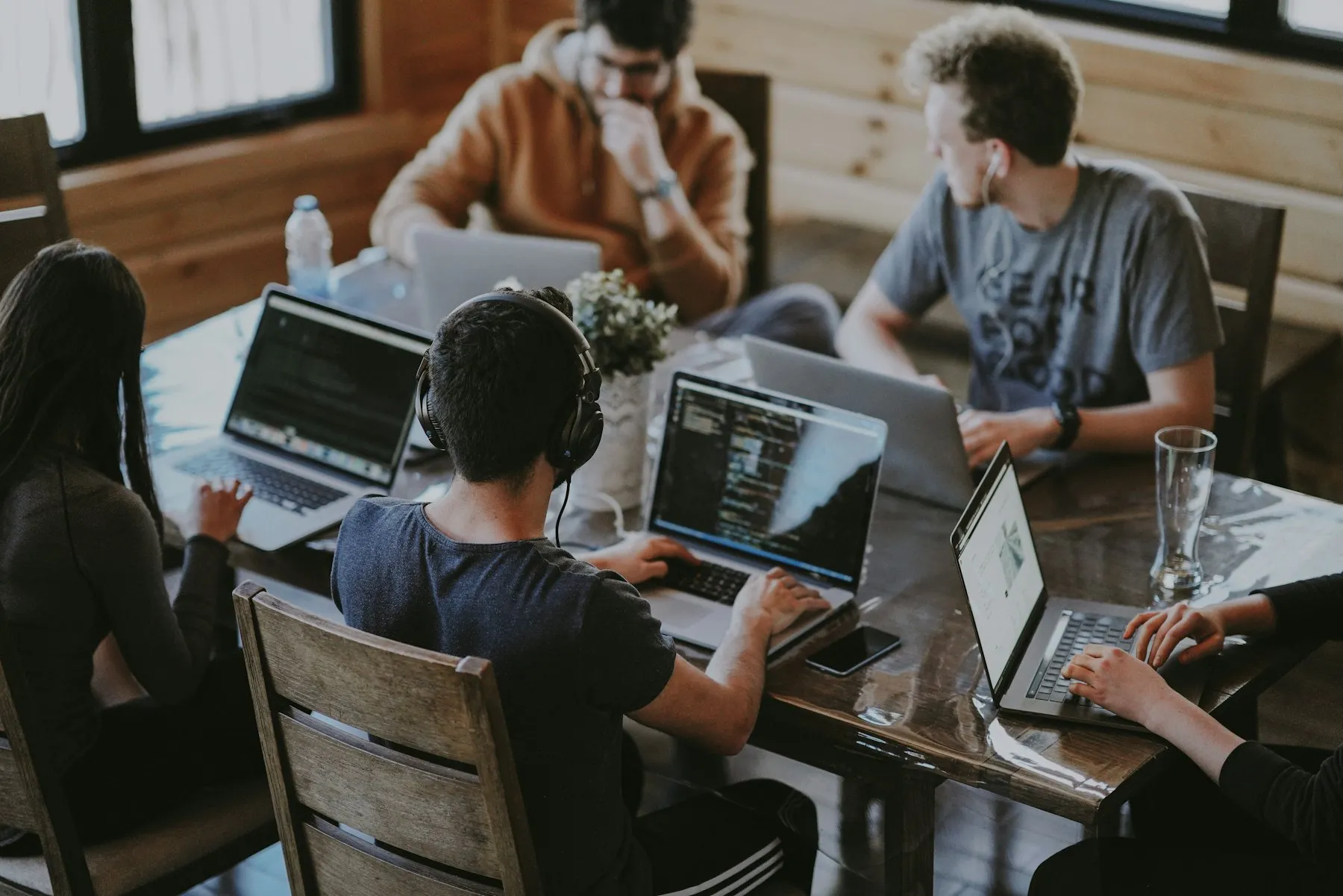 A marketing team reviewing campaign work together on laptops